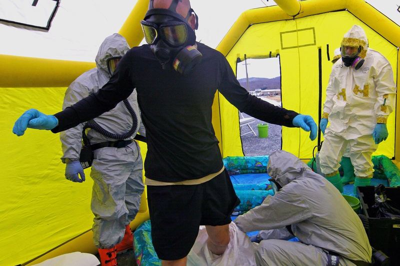 Responder carefully removing protective hazmat gear after a drill
